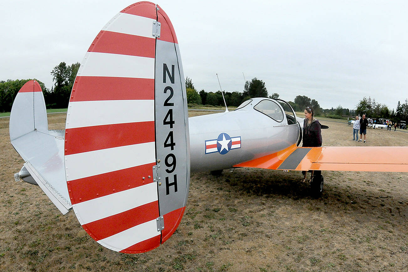 Josephine Camacho of Sequim examines a 1946 vintage Ercoupe 415-C belonging to Kevin and Charlene Tracy of Diamond Point as it sits on display during the Olympic Peninsula Air Affaire on Saturday at Sequim Valley Airport. The fly-in event featured modern and classic aircraft, as well and an antique auto show, displays, food and music. (Keith Thorpe/Peninsula Daily News)