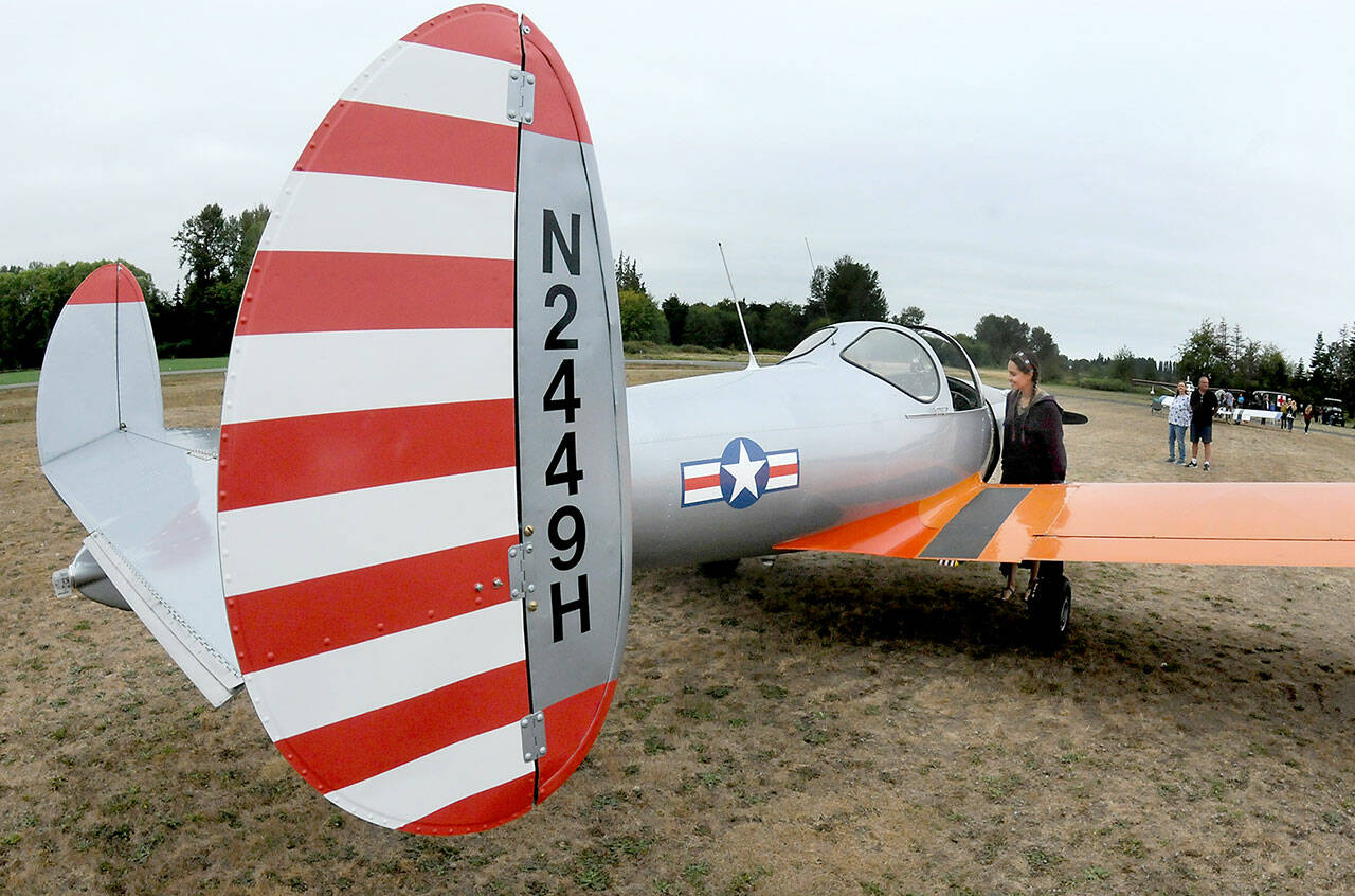 Josephine Camacho of Sequim examines a 1946 vintage Ercoupe 415-C belonging to Kevin and Charlene Tracy of Diamond Point as it sits on display during the Olympic Peninsula Air Affaire on Saturday at Sequim Valley Airport. The fly-in event featured modern and classic aircraft, as well and an antique auto show, displays, food and music. (Keith Thorpe/Peninsula Daily News)