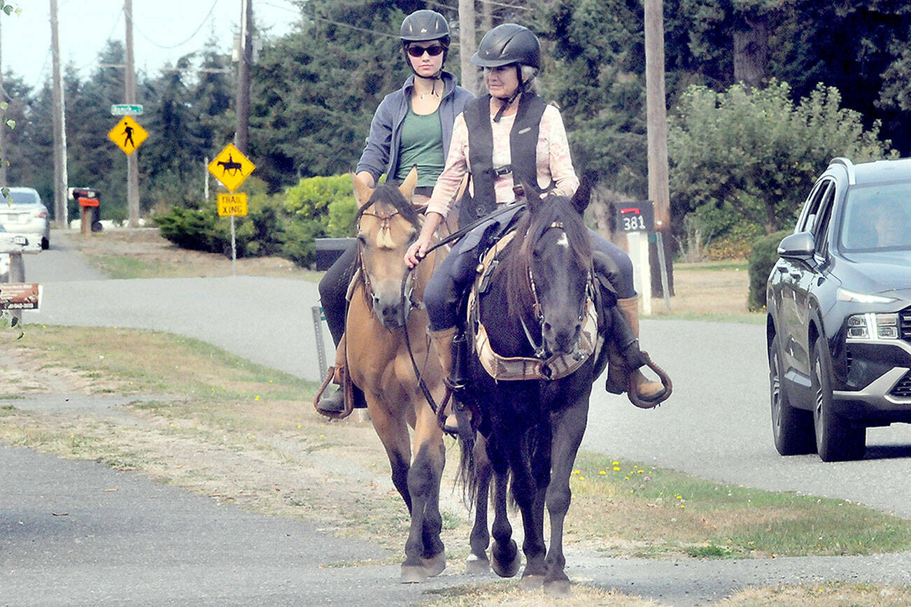 Julie Kustura and her horse Rocky, front, and Kari Olson riding Spirit, make their way down an equestrian trail paralleling the Olympic Discovery Trail along Vautier Road west of Sequim on Thursday. The pair were on their way to nearby Robin Hill Farm County Park and its collection of horse and pedestrian trails. (Keith Thorpe/Peninsula Daily News)