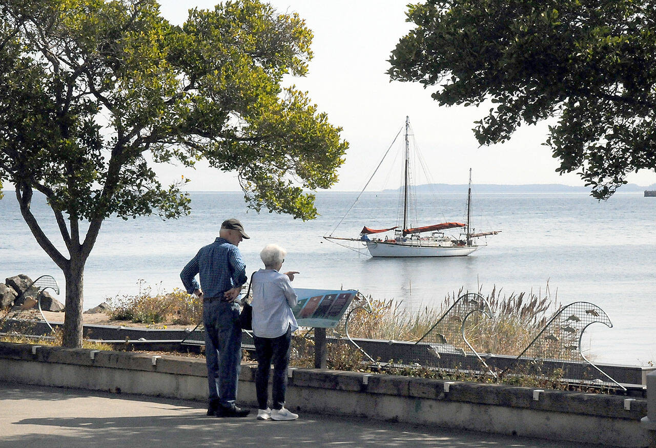 Wayne and Carolyn Stewart of Portland, Ore., look over Port Angeles Harbor as the sailboat Cytherea, homeported in Tomales Bay, Calif., sits at anchor off Port Angeles City Pier. The Stewarts were visiting the North Olympic Peninsula with plans for a journey to Victoria. (Keith Thorpe/Peninsula Daily News)