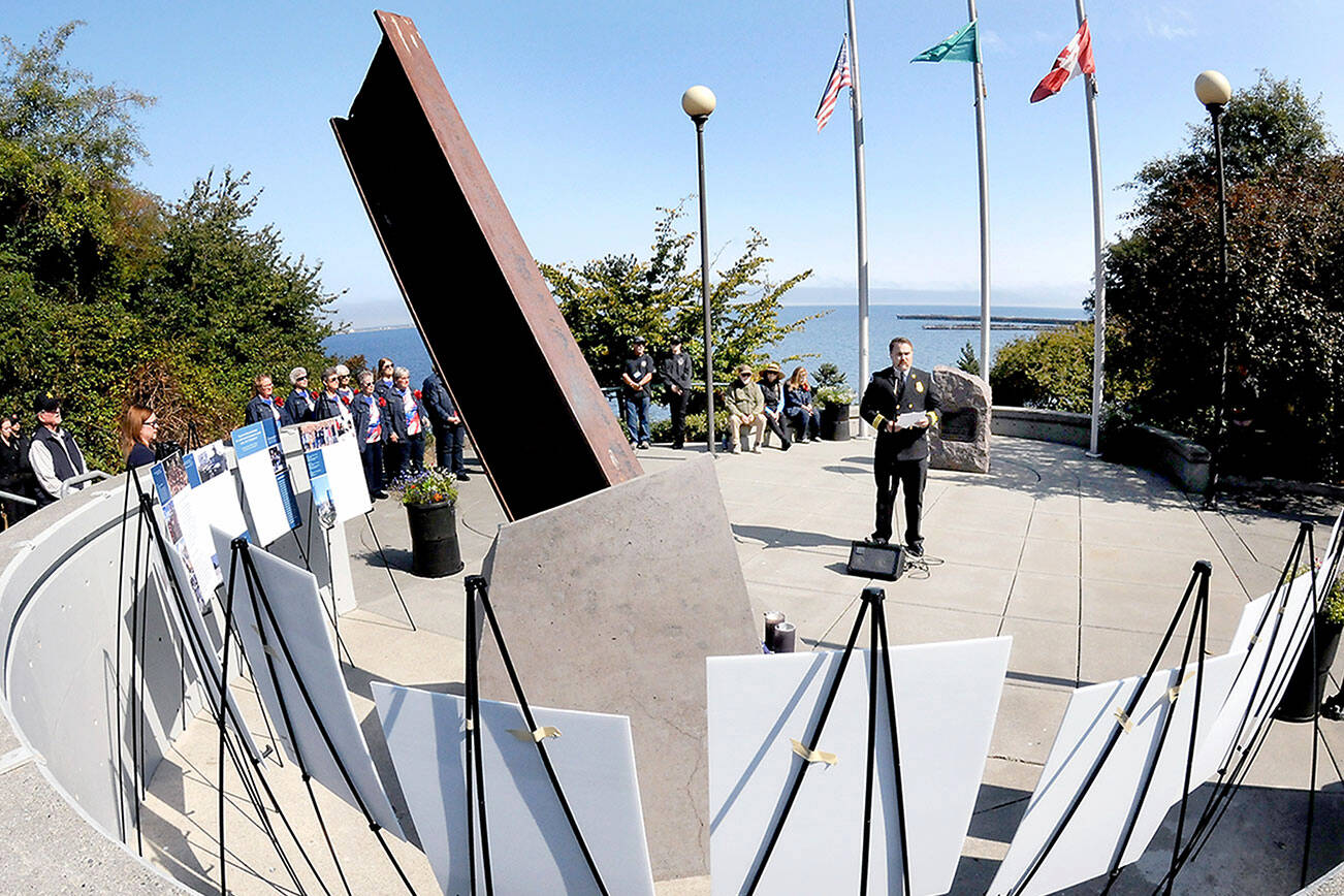 Division Chief Tyler Gage of the Port Angeles Fire Department delivers remarks how firefighters and first responders were affected by the events of Sept. 11, 2001, during a remembrance ceremony on Thursday at the twin monuments at 9/11 Memorial Waterfront Park in Port Angeles. The ceremony also included a flag presentation, comments from law enforcement officials and music by the Grand Olympics Chorus. (Keith Thorpe/Peninsula Daily News)