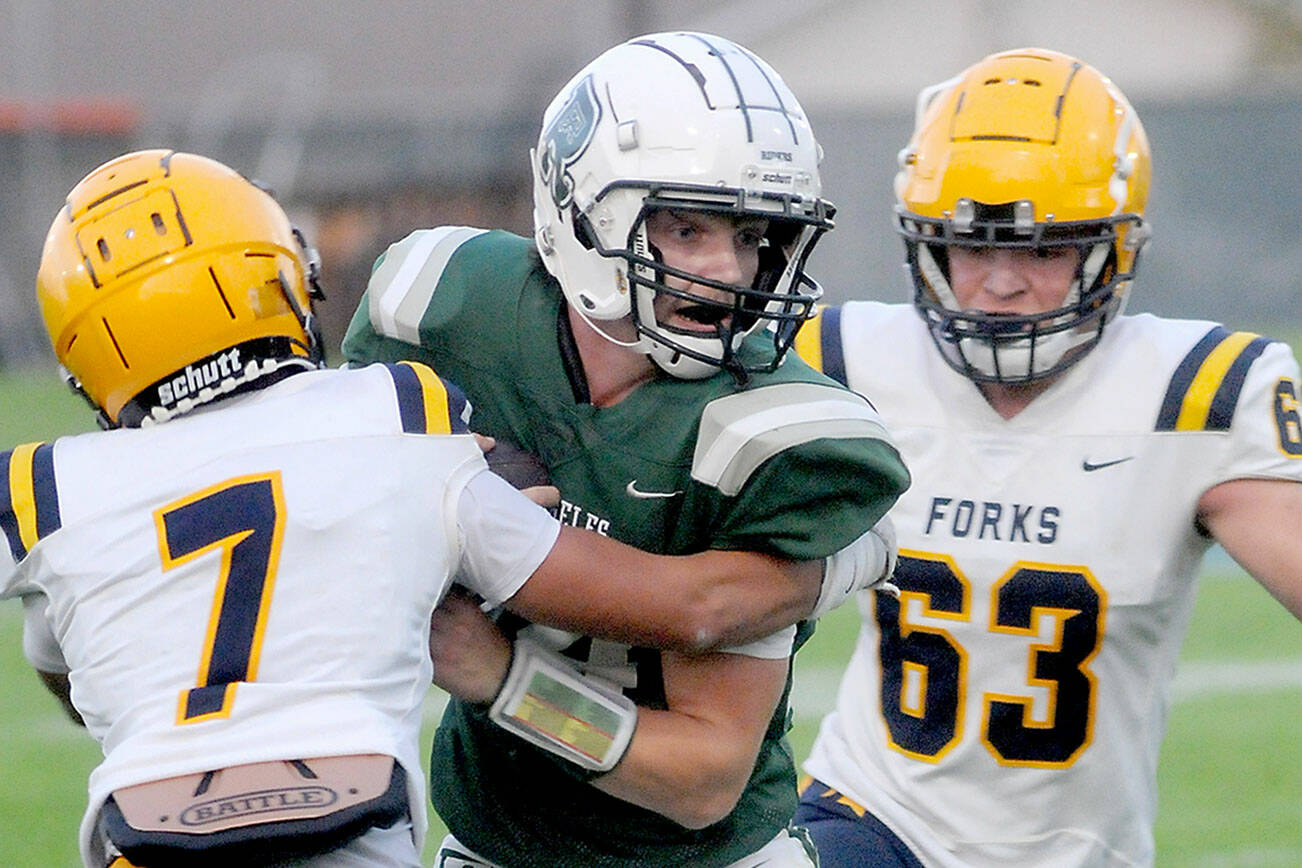 KEITH THORPE/PENINSULA DAILY NEWS
Port Angeles' Jude Wallace, center, tries to escape the clutches of Forks' Estevan Ramos, left, and Adon Arellano on Friday at Port Angeles Civic Field.