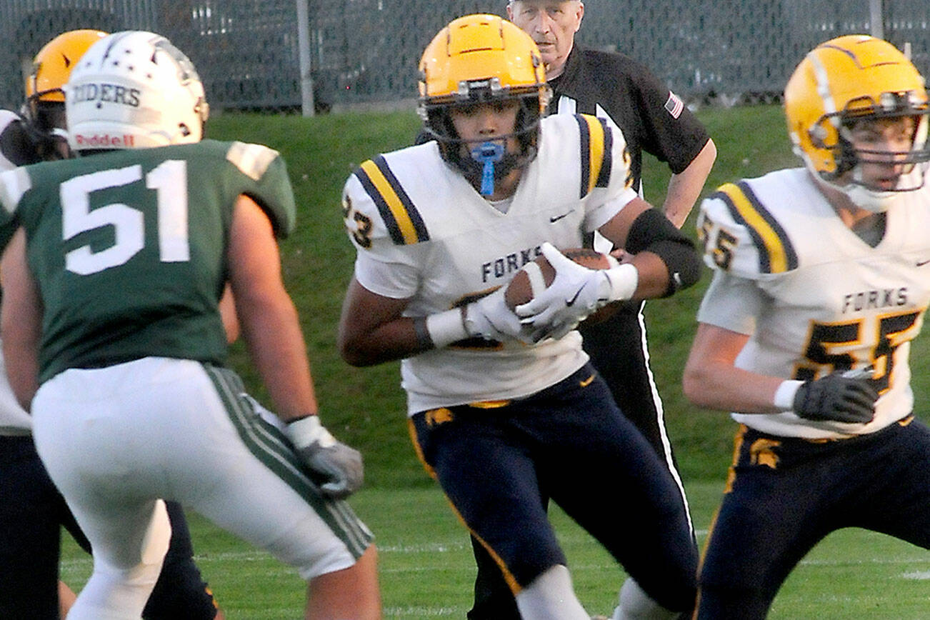 Forks tight end Kaden Ward, center, scrambles for a way past Port Angeles’ Hunter Flores as teammate Conner Roberts, right, sets up a block on Friday evening in Port Angeles. (Keith Thorpe/Peninsula Daily News)