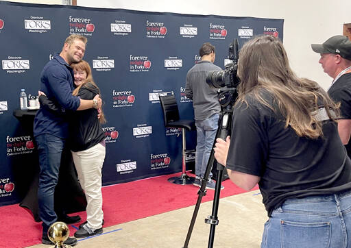 Actor Kellan Lutz, left, hugs a fan during a “meet the actors photo session” during the Forever Twilight Forks event on Friday. All VITs had the opportunity for a photo and to get one item signed. Lutz played Emmett Cullen in The Twilight Saga film series. Also attending were Peter Facinelli, who played Dr. Cullen, seen at right, and actor and regular participant Erik Odom. Author Stephenie Meyer attended for the first time in many years. An estimated 1,000 people attended the Q&A with Meyer and movie at the Kitla Center. (Christi Baron/Olympic Peninsula News Group)