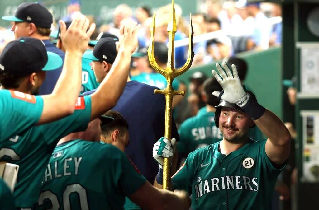 Cal Raleigh is congratulated by his teammates after hitting two home runs Tuesday night against Kansas City, tying him with Ken Griffey Jr. for the most home runs in a season by a Mariner. (Getty Images)