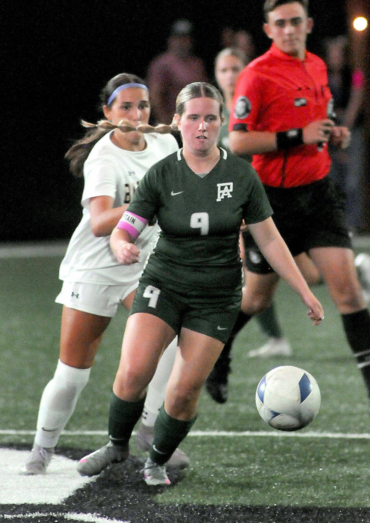 Port Angeles’ Allison Fricker, front, approaches the ball ahead of Bainbridge’s Isabella Saint Clair on Tuesday night at Peninsula College. (Keith Thorpe/Peninsula Daily News)