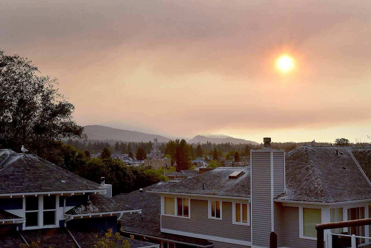 The sun shines through a layer of clouds and wildfire smoke as it begins to set on Tuesday in Port Angeles. (Keith Thorpe/Peninsula Daily News)
