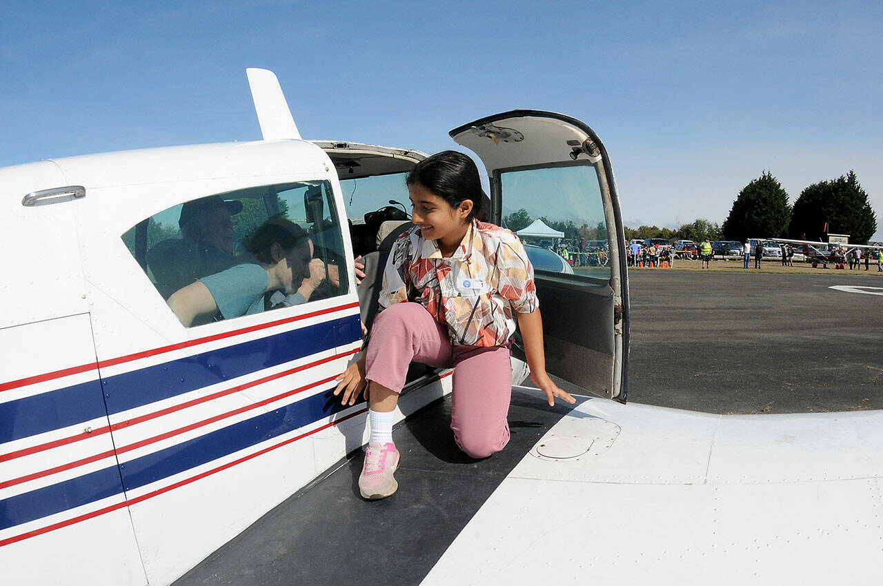 Aadya Karanam, 10, of Monroe emerges from the cabin of a Piper PA-24-250 after taking her Young Eagles flight on Saturday at Sequim Valley Airport. The event, part of a nationwide pilots initiative to introduce children to aviation, was hosted locally by the Experimental Aircraft Association Chapter 430. About 40 youngsters were signed up free plane rides on Saturday. (Keith Thorpe/Peninsula Daily News)