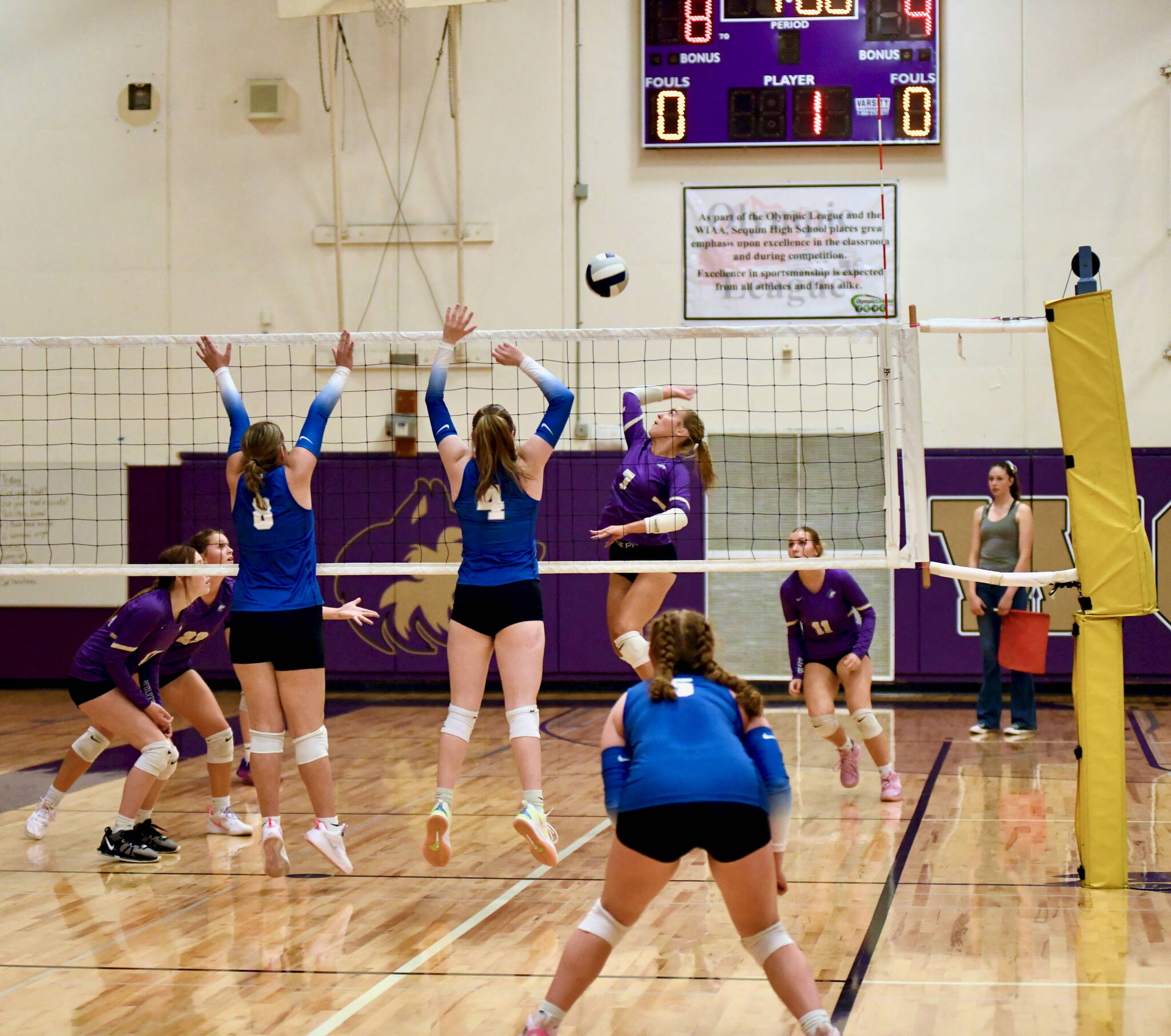 Sequim’s Sydney Clark (right) sets up a spike as Olympic’s Viktoria Blasco (far left) and Paige Pruitt prepare for the Wolf attack.