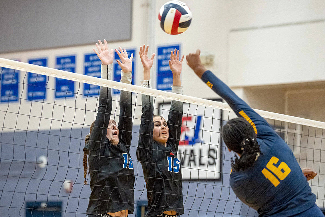 Steve Mullensky/for Peninsula Daily News

Rivals Emma Joy, #18, and Penina Vailolo, #15, jump up to block a spike by Annie Wright Gator Ni'Yah Christopher during a game played on Wednesday in Chimacum.
