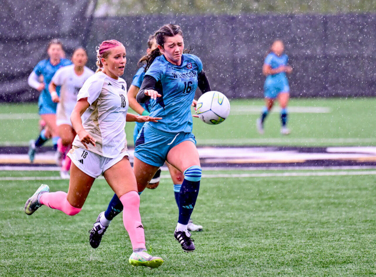 Peninsula College’s Kasi Baker (18) battles Whatcom’s Annabelle Jackson (16) for a loose ball int he rain at Wally Sigmar Field in Port Angeles on Saturday. (Jay Cline/Peninsula College)