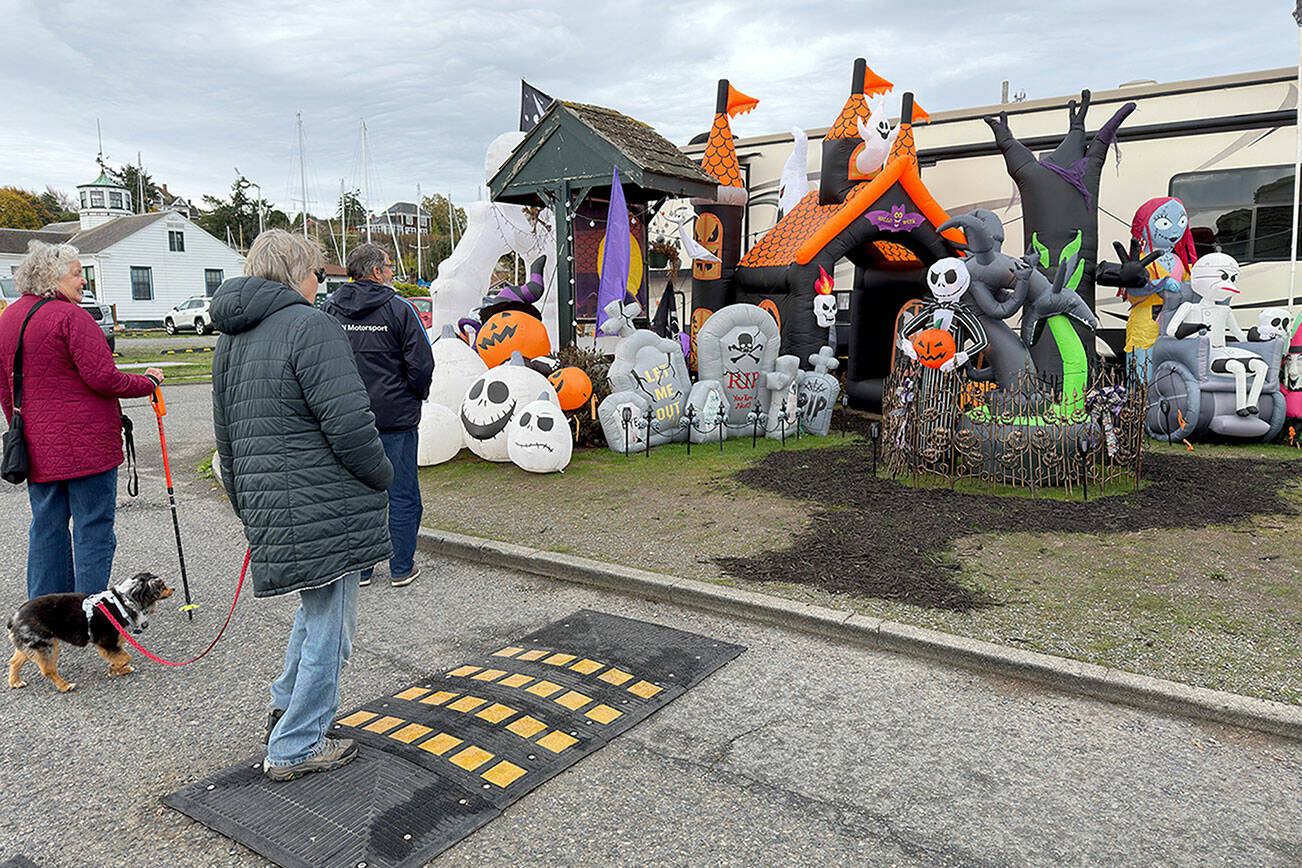 A group of friends stop to look at a Halloween display put up by the camp host at the RV park at Point Hudson Marina. (Steve Mullensky/for Peninsula Daily News)