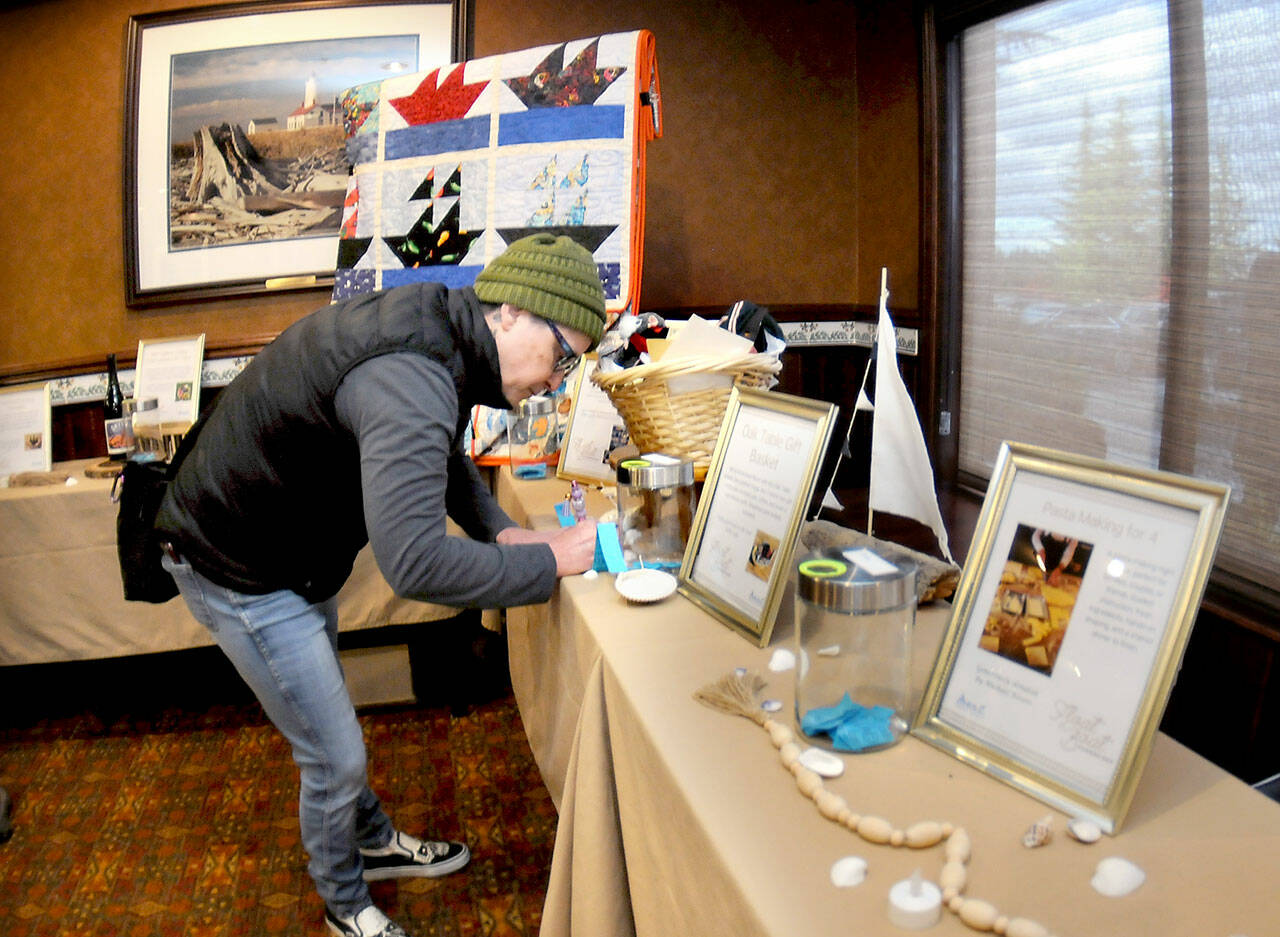Rachel Anderson of Port Angeles fills out a raffle ticket for gifts and nautical-themed items during Wednesday’s Float the Boat fundraiser benefitting the Port Angeles junior and senior high school sailing teams. The event, held at Olympic Lodge by Ayres in Port Angeles, was conducted by the nonprofit Community Boating Program to support youth sailing and other nautical programs. (Keith Thorpe/Peninsula Daily News)
