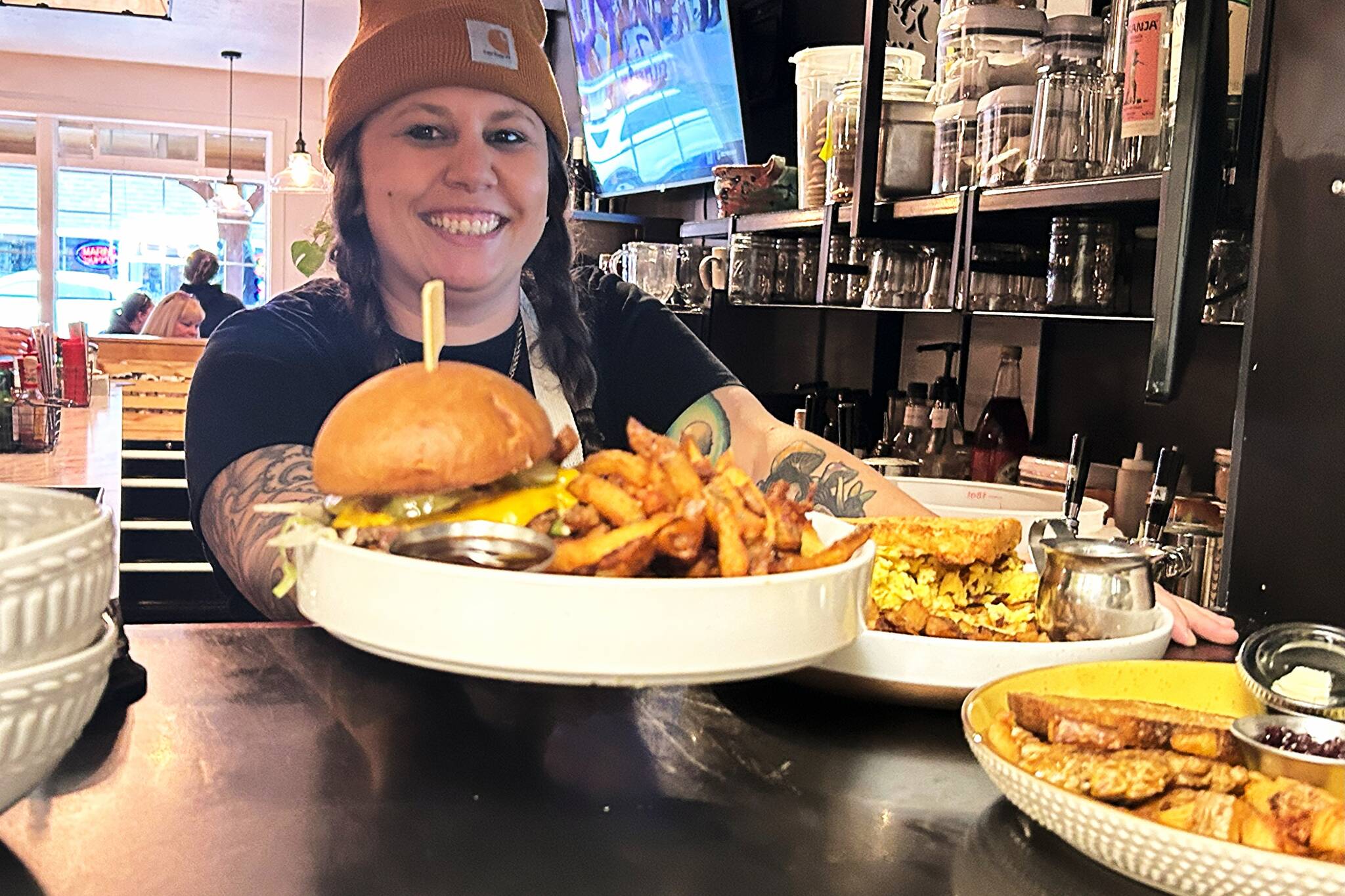 Jaclyn Wagner, co-owner of Sunshine Cafe and Bar, carries out an order to customers. She and her partner Alex Kirchner bought the restaurant just over a year ago and encourage locals to make it a weekly stop, whether for lunch or just coffee. (Matthew Nash/Olympic Peninsula News Group)
