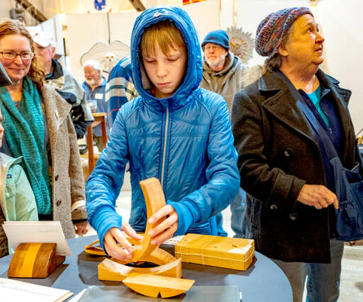 Byron Eisele, 13, of Port Townsend, assembles a build-your-own sculpture from a kit made by Seth Rolland while at the 20th annual Port Townsend Woodworkers Show at the American Legion Hall last weekend. (Steve Mullensky/for Peninsula Daily News)