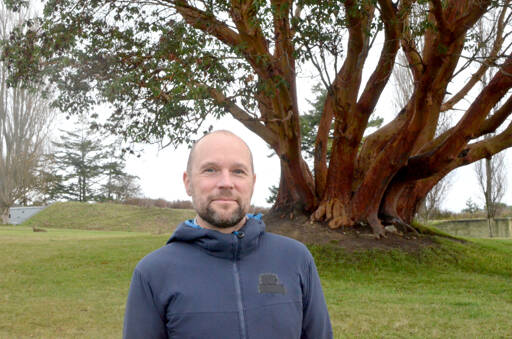 Erik Kingfisher near a large Madrona at Fort Worden State Park on Tuesday after receiving the Eleanor Stopps Environmental Leadership Award. (Elijah Sussman/Peninsula Daily News)