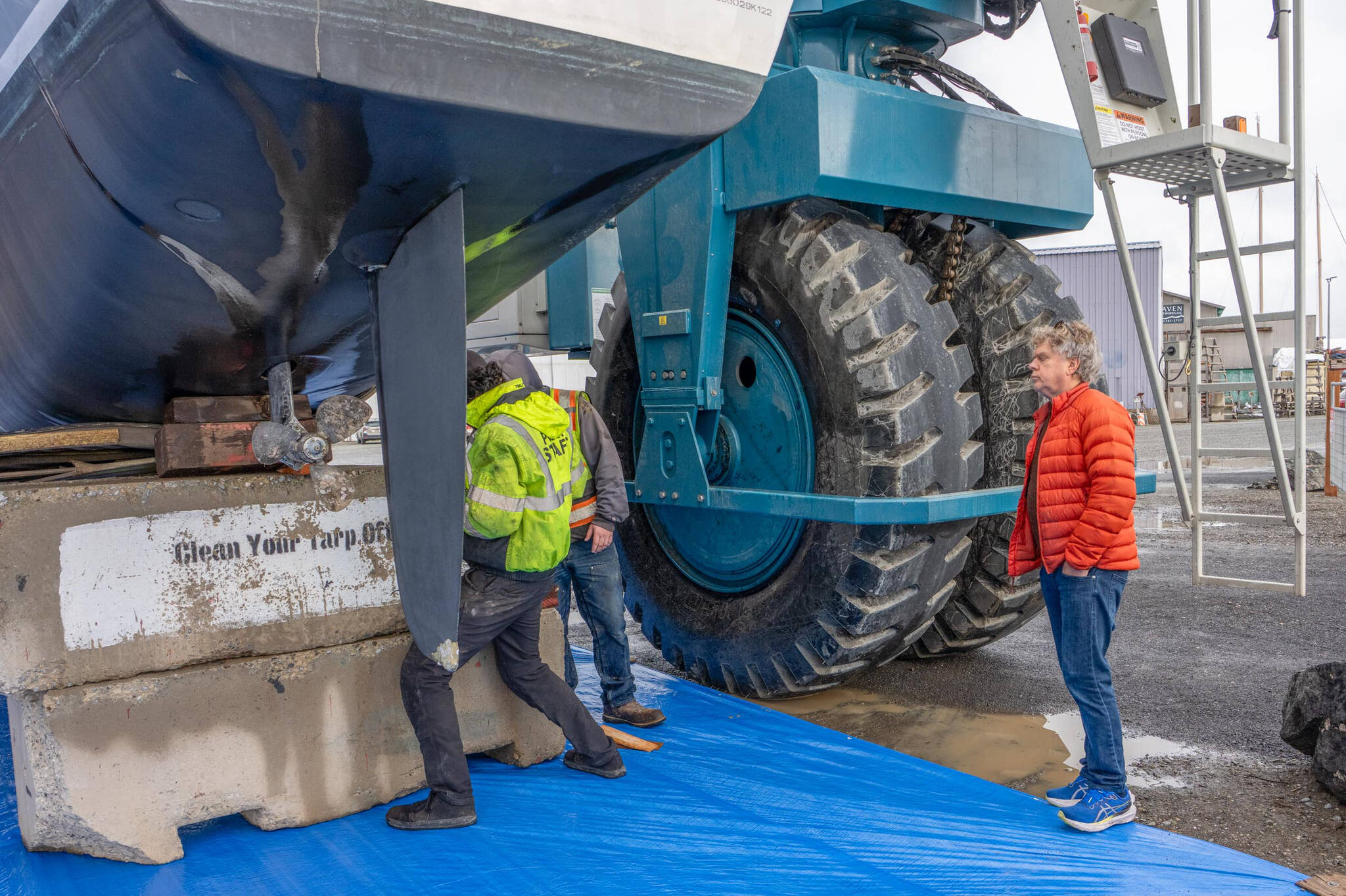 Steve Mullensky/for Peninsula Daily News
Michael McBurnie, from Bainbridge Island, watches as Port of Port Townsend workers insert shims to help support his 42-foot Leopard catamaran, Celestial Sky, on the hard on Tuesday. McBurnie had the boat out of the water for maintenance as well as to repair damage to the tip of the rudder.