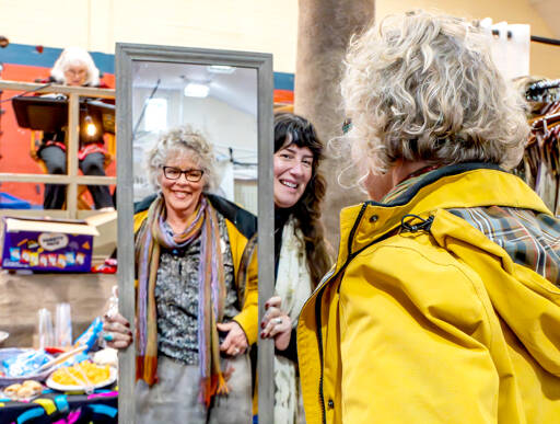 Kendra Russo of Found and Foraged Fibers in Anacortes holds a mirror as Jayne Johnson of Sequim tries on a skirt during a craft fair on Saturday in Uptown Port Townsend. (Steve Mullensky/for Peninsula Daily News)
